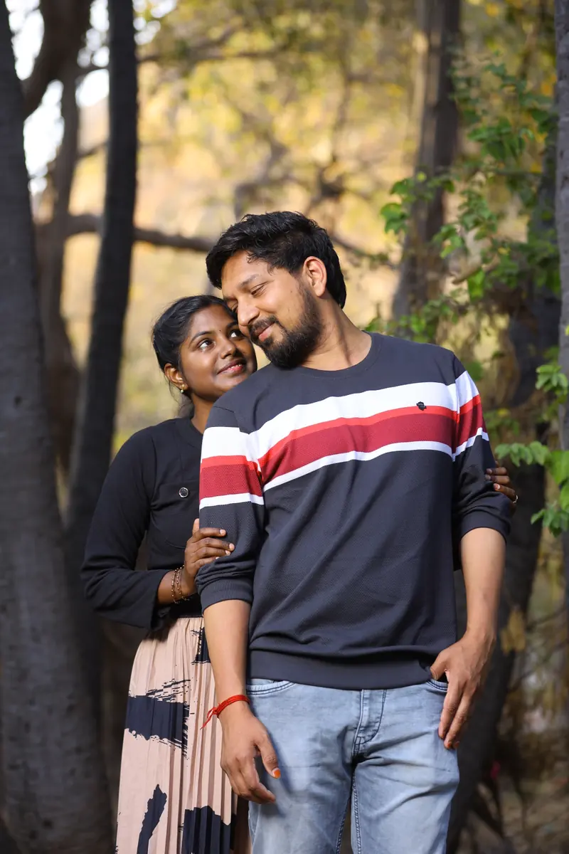 Couple sharing a quiet moment among trees at their pre-wedding shoot